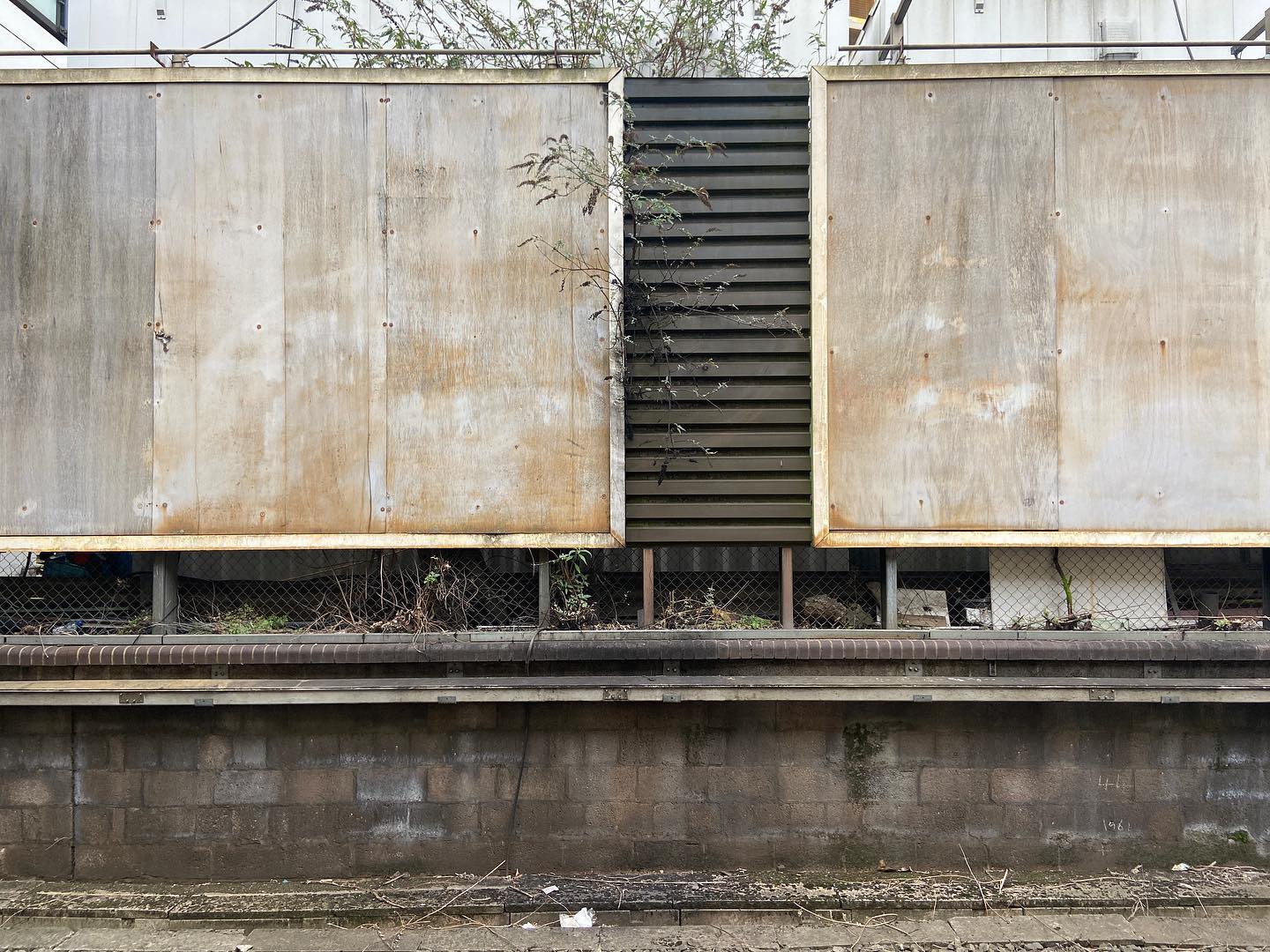 stripped billboards shout nothing loudly across railway line