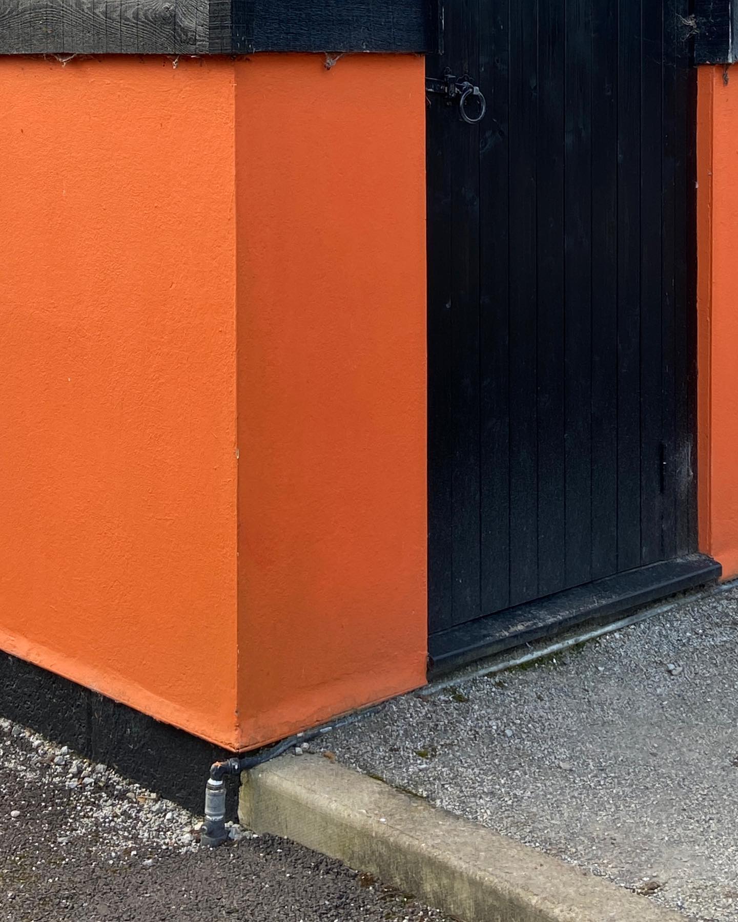 orange corner with sharp black trim, gravel step as grey doormat