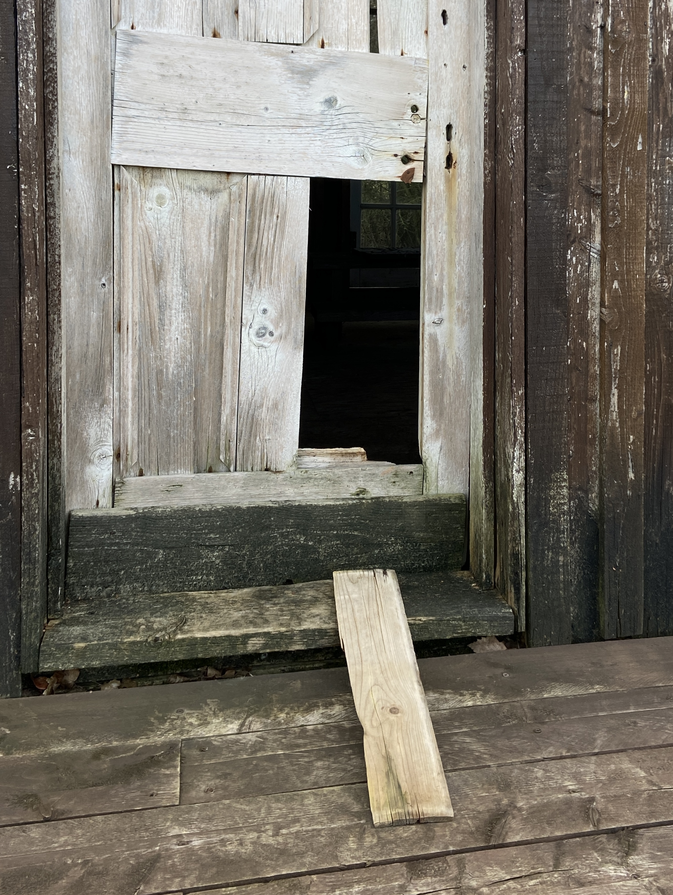 door with hole, missing plank gestures towards in a beckoning gesture